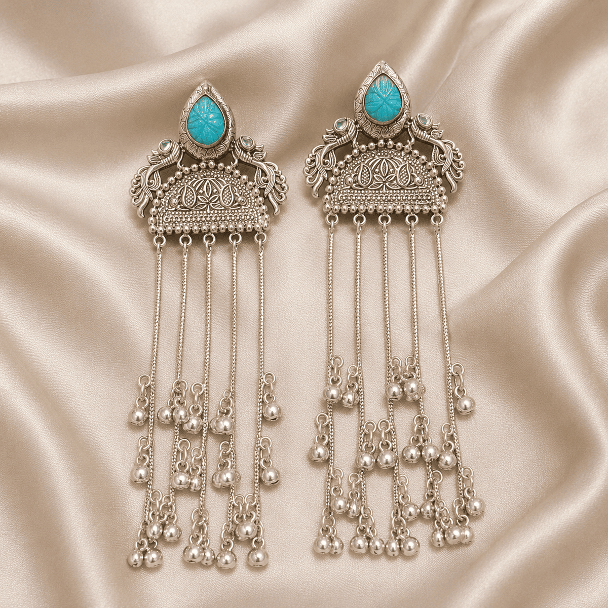 Turquoise cabochon jhumka tassel earrings featuring long silver-tone bell fringe