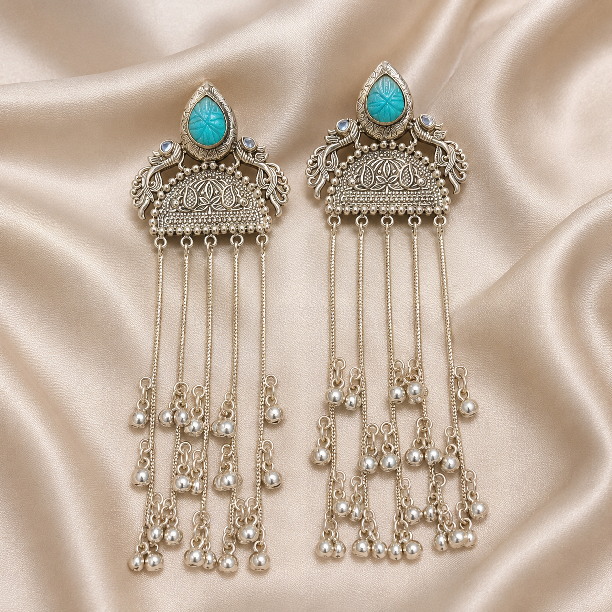 Turquoise cabochon jhumka tassel earrings featuring long silver-tone bell fringe