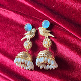 Gold and pearl earrings on a red velvet background