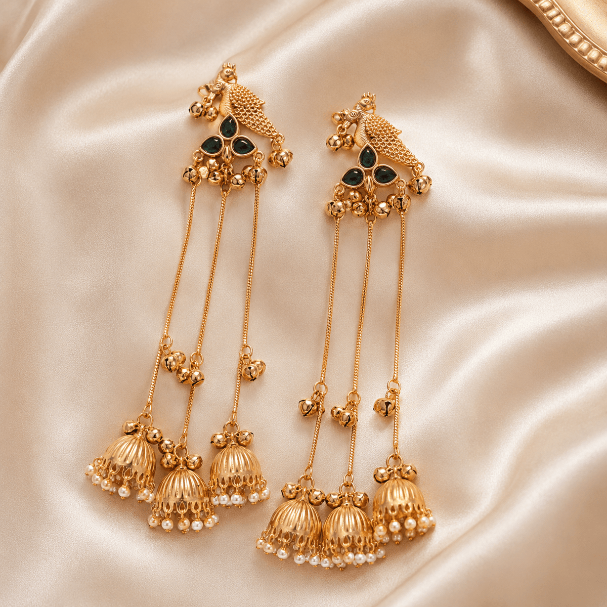 Gold-tone bird motif jhumka drop earrings with green stone accents and pearl fringe