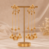 Gold-tone bird motif jhumka drop earrings on display stand, long chain tassels