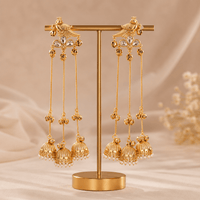 Gold-tone bird motif jhumka drop earrings on display stand, long chain tassels