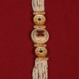 Decorative bracelet with gold and white beads on a red background